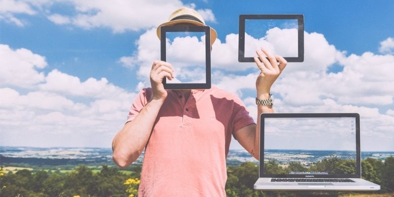 restore wordpress from backup laptop tablet sky field view Photo of man holding tablet over his face and in the air, with laptop next to him all showing photos of the landscape directly behind them