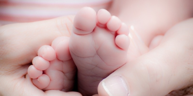 Mom & Parenting Pinterest Communities for bloggers header with baby feet held by mom's hand