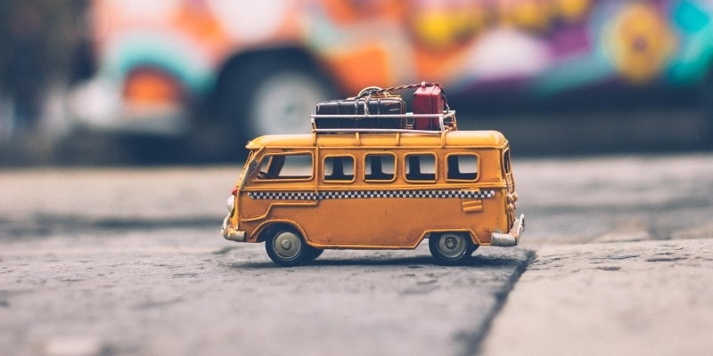 Travel Pinterest Communities for bloggers header of yellow toy camper van carrying suitcases