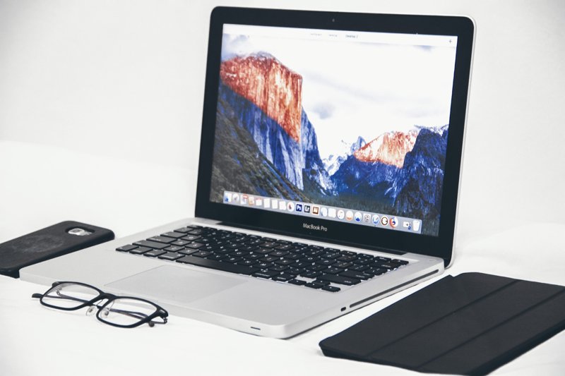 Pinterest widget header image of laptop on white surface with smartphone, glasses and tablet case