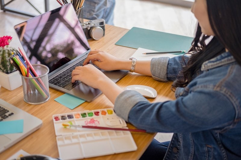 How To Use Pinterest For Business Using This Pinterest Strategy Header Image Of Woman Typing At Laptop
