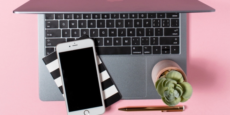 Blog Image Mistakes Header Image Of Silver Laptop Open With Striped Notepad, Mobile Phone And Potted Plant