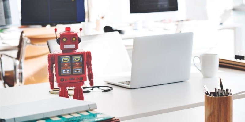 Why Use WordPress For Blogging Header Image Of White Office With Laptop And Red Robot