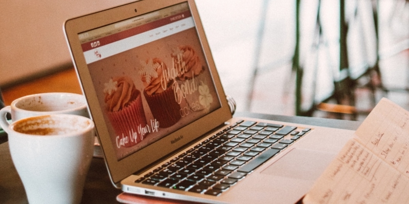 How To Update A WordPress Website Header Image Of Laptop In Coffee Shop With Website Displayed