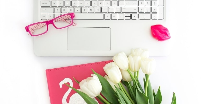 Laptop For Blogging And Using WordPress With Bright Pink Notebook, Glasses And White Tulips