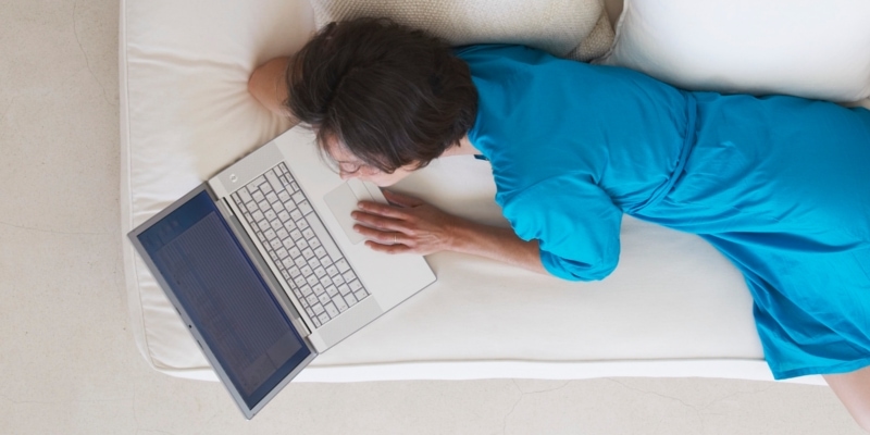 Female Blogger On Sofa In Blue Dress Learning How To Write Blog Posts Faster