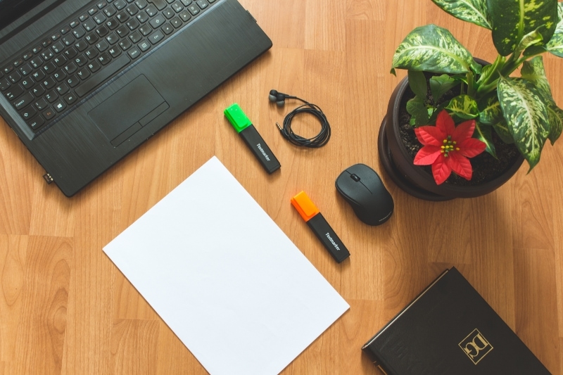 Blogging Office Desk With Black Laptop Notebook And Stationary With Red Potted Flower 1