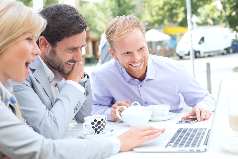 Entrepreneur Bloggers Smiling While Using Laptop And Drinking Coffee Outside 1